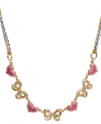 Flaunt sweet femininity. Betsey Johnson's flirty frontal necklace features pave-set crystal hearts and ribbons in clear and pink hues. Crafted in gold tone mixed metal with crystal cup chain accents. Approximate length: 16 inches + 3-inch extender. Approximate drop: 5/8 inch.